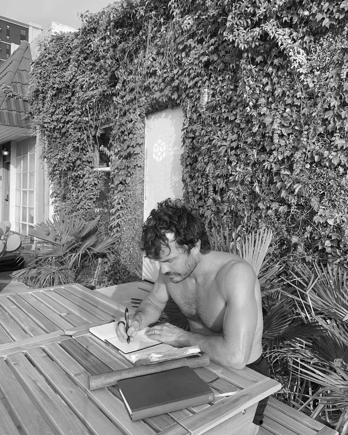 Carter Twitty writing in a notebook at an outdoor table